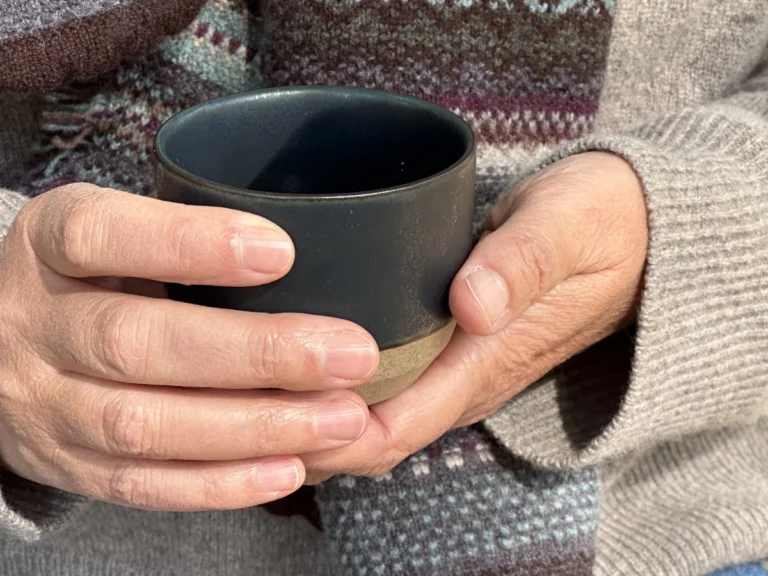 Eine Tasse Tee in den Händen als Symbol für Selbstfürsorge