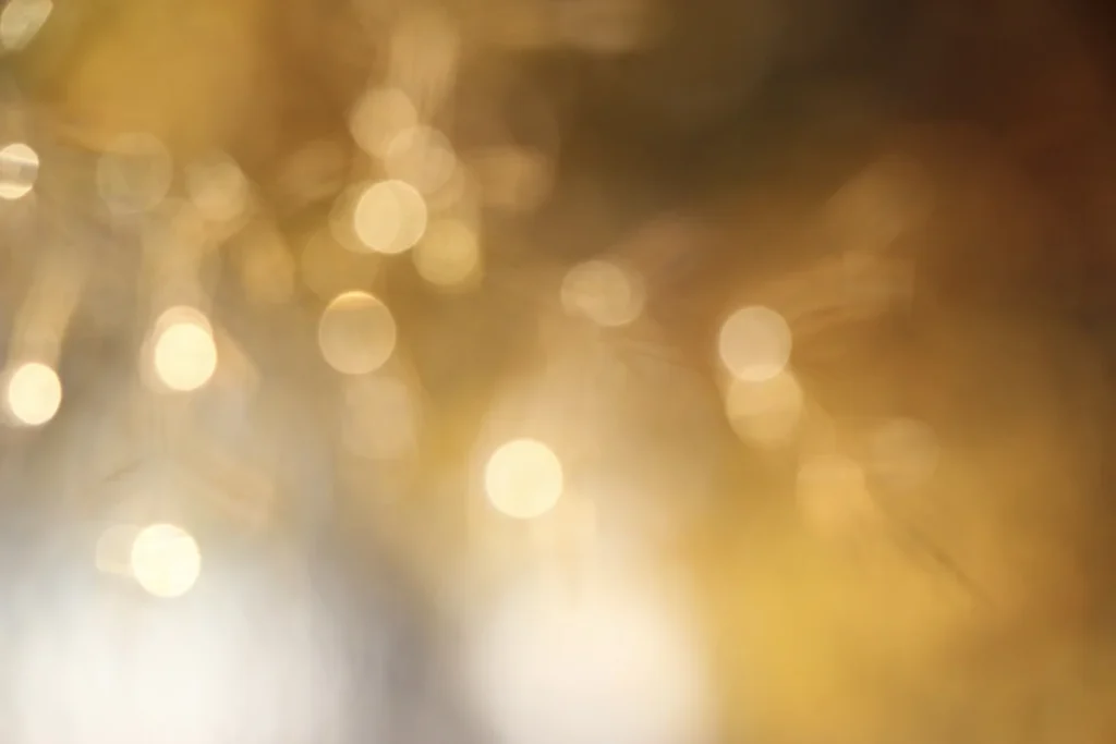 Lichtpunkte in goldenem Licht vor unscharfem Hintergrund.