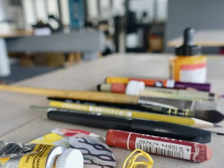 Arbeitstisch im Atelier mit vielseitigen Stiften und Farben