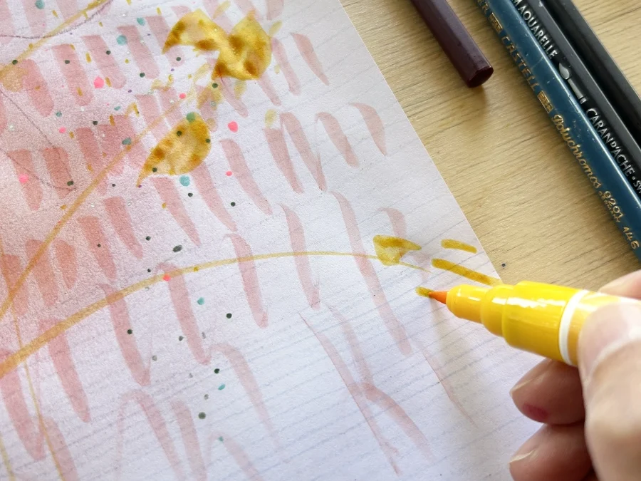 Hand zeichnet mit einem Farbstift auf Papier – kreativer Ausdruck als achtsame Übung.